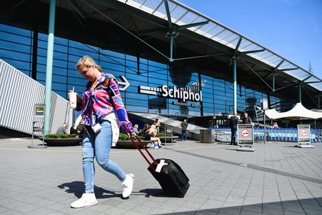 Une femme avec une valise passe par l'aeroport de schiphol a amsterdam, aux pays-bas