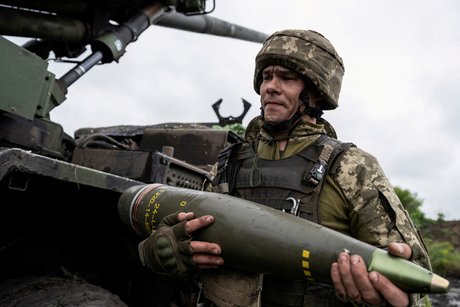 Un militaire ukrainien porte un obus pour un obusier automoteur caesar avant de tirer en direction des troupes russes pres d'avdiivka