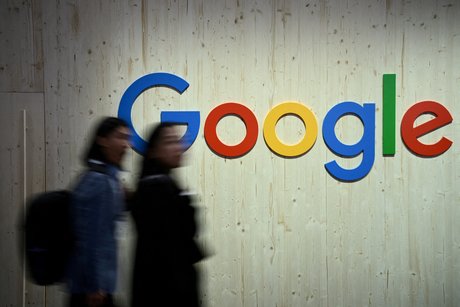 Des personnes marchent a cote d'un logo google
