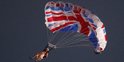Un artiste saute en parapente avec un costume de la reine d'Angleterre et le drapeau du Royaume-Uni pour la cérémonie d'ouverture des JO de Londres