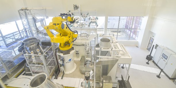 Un ilot de travail homme-machine dans l'usine B-Line d'ArianeGroup avec au centre en jaune un robot Fanuc.