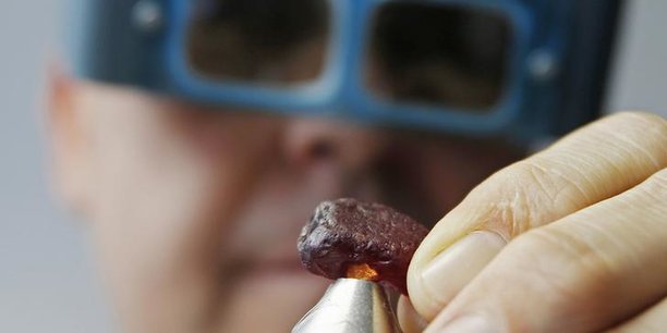 Ian Harebottle, directeur général de Gemfield, est en train d’inspecter un rubis brut de 40,23 carats découvert dans son gisement de Montepuez au Mozambique, au cours d'une vente aux enchères le 4 décembre 2014, à Singapour.