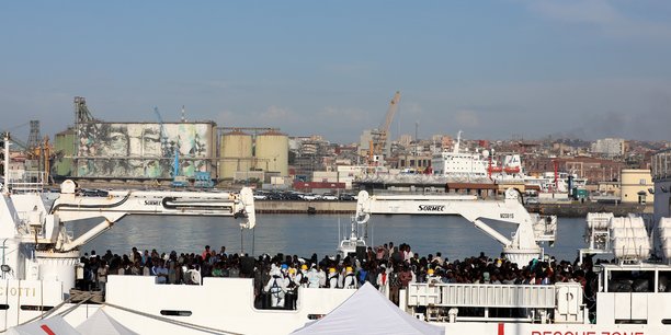 Migrants wait to disembark italian coast guard's vessel diciotti as they arrive at the catania harbour[reuters.com]