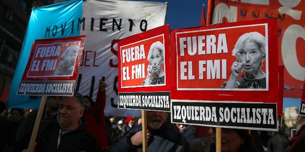 Des manifestants brandissent des pancartes hostiles aux accords conclus entre le FMI et l'Argentine.