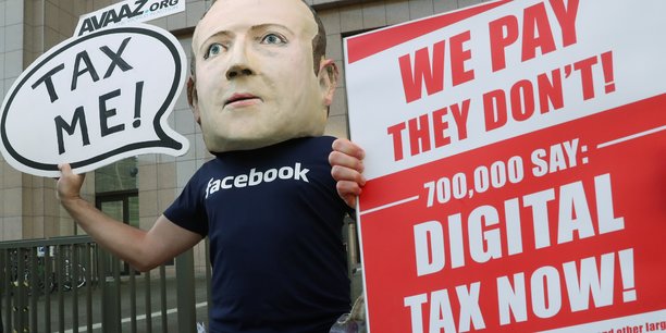 Les géants du numérique sous pression. Affublé d'une tête de Marc Zuckerberg, le PDG de Facebook, un manifestant réclame la taxation des Gafa devant le siège de l'UE, à Bruxelles, en décembre dernier.