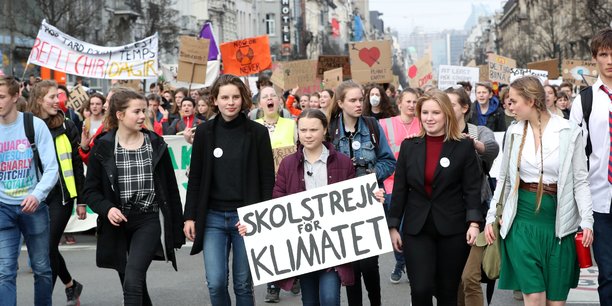 La jeune activiste suédoise Greta Thunberg (17 ans) ici, avec sa célèbre pancarte lors d'une manifestation à Bruxelles le 21 février dernier, entraîne les lycéennnes et lycéens européens dans des grèves pour le climat avec ses émules belges (telle Anuna De Wever, 17 ans également, ici à sa droite) et anglaises.