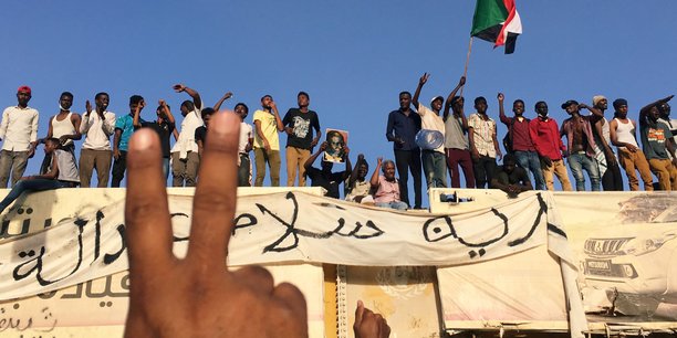 Des manifestants brandissant des banderoles et scandant des slogans demandant le départ du président Omar El Béchir, le 8 avril 2019 devant le ministère de la Défense à Khartoum, la capitale soudanaise.