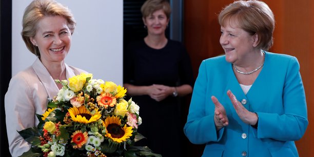 Ursula van der Leyen félicitée par Angela Merkel, bouquet de fleurs à l'appui, ce mercredi matin à Berlin.