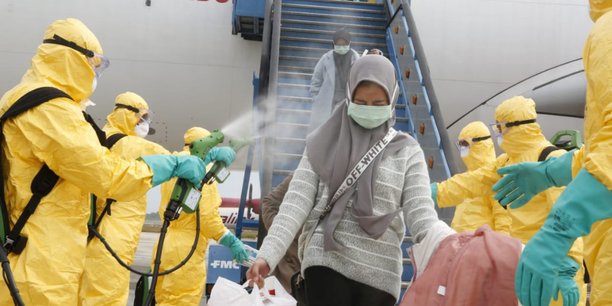 Des médecins diffusent un spray antiseptique sur une femme rapatriée de Chine en Indonésie, le 2 février 2020.