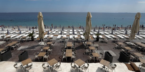 Sur une plage privée de la Promenade des Anglais, à Nice, le 30 mai 2020, les tables et transats sont alignés selon les recommandations de distanciation sociale consécutives à l'épidémie de Covid-19, afin d'être prêts pour la levée des restrictions de déplacements dans l'Hexagone mardi 2 juin.