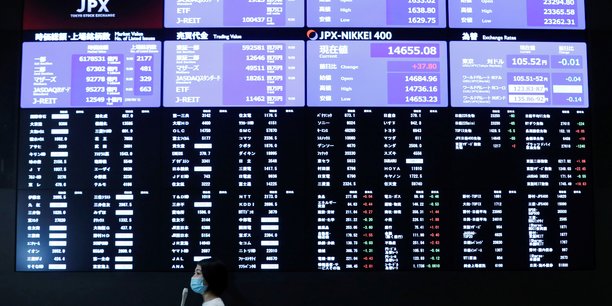 A tv reporter stands in front of a large screen showing stock prices at the tokyo stock exchange after market opens in toky[reuters.com]