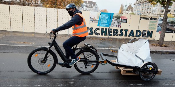 Les livreurs strasbourgeois transportent les pavés à l'aide d'un vélo électrique, équipé d'une remorque.
