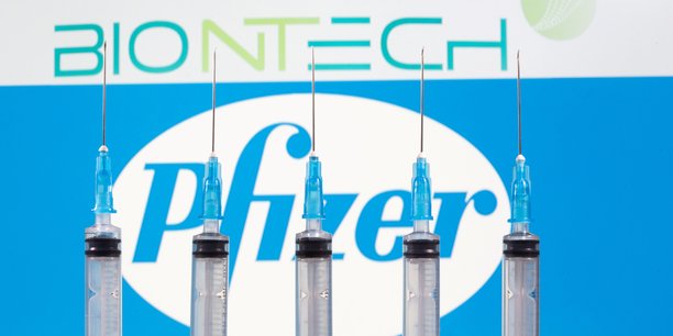 File photo: syringes are seen in front of displayed biontech and pfizer logos in this illustration[reuters.com]