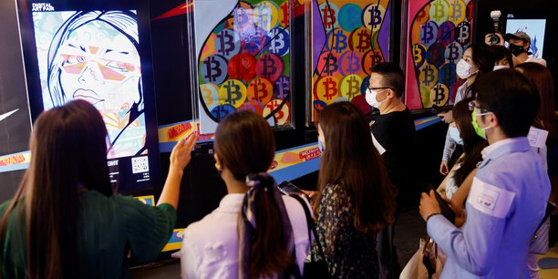 Photo d'illustration: le 30 septembre dernier, le public se presse devant Hold onto your Bitcoin. Cette oeuvre de l'artiste Gustav Szabo, plus connu sous le nom de Szabotage, sera ensuite convertie en NFT et mise aux enchères en ligne chez Sotheby's, à la Digital Art Fair de Hong Kong (Chine).
