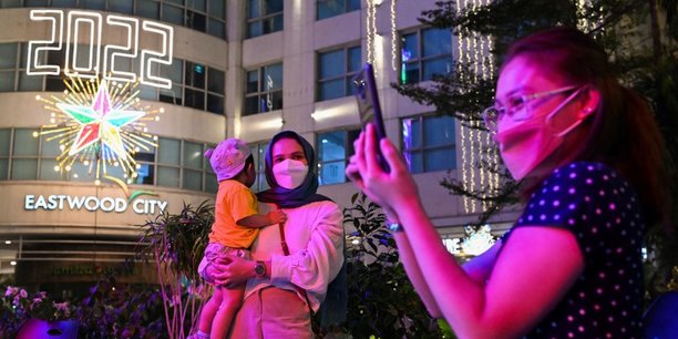 Une femme et un enfant posent pour une photo lors de la célébration du Nouvel An à Eastwood Mall, à Quezon City, aux Philippines, le 1er janvier 2022.