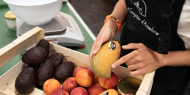 Marie Franco, fondatrice du Comptoir d'Anselme montre les fruits et légumes sauvés de la benne par son initiative.