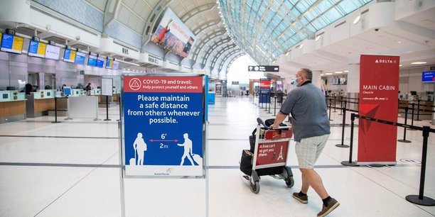 Un homme pousse un chariot a bagages a l'aeroport pearson de toronto[reuters.com]