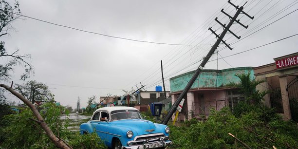 Une voiture de collection passe a cote de debris causes par l'ouragan ian lors de son passage a pinar del rio, a cuba[reuters.com]