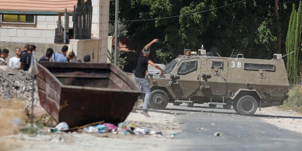 Un palestinien lance une pierre sur un vehicule de l'armee israelienne[reuters.com]