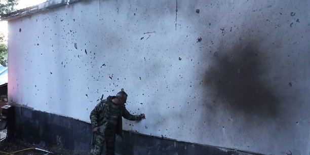 Un homme se tient a cote d'un batiment endommage par les  bombardements lors des affrontements frontaliers avec l'azerbaidjan[reuters.com]