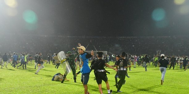 Des supporters entrent sur le terrain pendant l'emeute qui a suivi le match de football entre arema vs persebaya au stade kanjuruhan[reuters.com]
