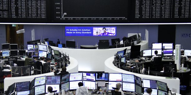 Photo des traders travaillant a leur bureau devant l'indice boursier allemand[reuters.com]