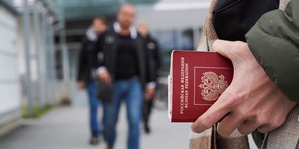 Photo d'une personne tenant son passeport russe[reuters.com]