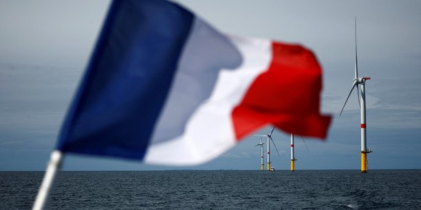 Un drapeau francais devant les eoliennes du parc eolien offshore de saint-nazaire[reuters.com]
