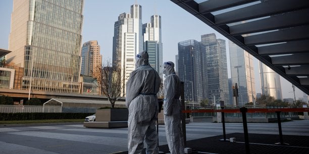 Les autorites en tenue de protection gardent l'entree d'un immeuble de bureaux a pekin, en chine[reuters.com]