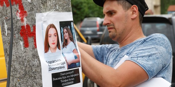 Photo d'archives d'un homme posant une affiche sur une personne disparue, a vinnytsia[reuters.com]