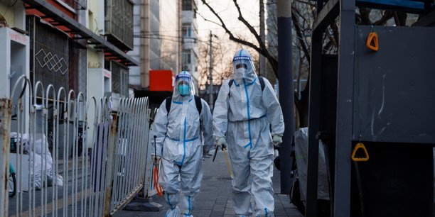 Photo des agents de prevention, dedies a la lutte a la pandemie de la covid-19, marchent dans une rue de pekin[reuters.com]