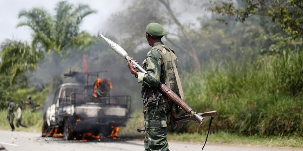 Un soldat congolais des forces armees de la republique democratique du congo (fardc) regarde son vehicule en feu[reuters.com]