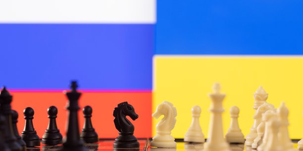Des pieces de jeu d'echec devant les drapeaux de la russie et de l'ukraine[reuters.com]