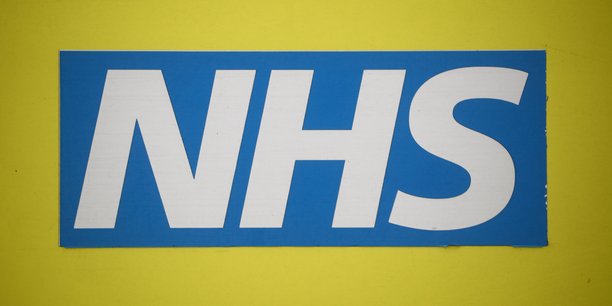 Le logo du nhs est visible sur une ambulance garee devant l'hopital nightingale au centre excel, a londres[reuters.com]