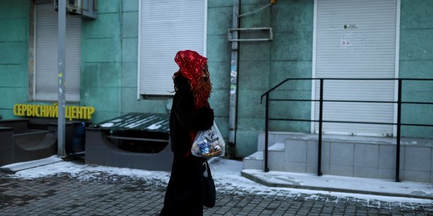 Une femme porte un sac avec de la nourriture alors qu'elle marche dans une rue a odessa, ukraine[reuters.com]