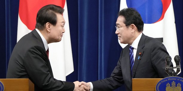Le Premier ministre japonais Fumio Kishida (à droite) et le président sud-coréen Yoon Suk Yeol se serrent la main lors d'une conférence de presse conjointe à l'issue de leur entretien au bureau du Premier ministre à Tokyo, le 16 mars 2023. Yoon Suk Yeol est en visite pour deux jours au Japon, ce qui représente le plus important sommet entre Tokyo et Séoul depuis 12 ans.