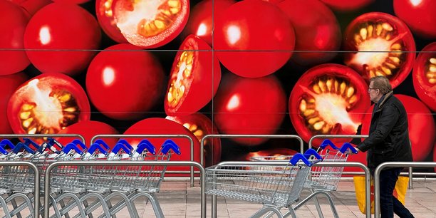 Un acheteur devant un supermarche a londres[reuters.com]