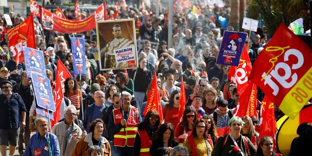 Des manifestants du syndicat cgt tiennent une pancarte representant le president francais emmanuel macron[reuters.com]