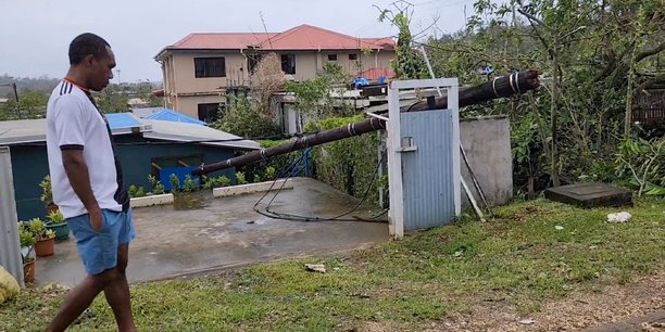 Un homme marche a cote d'un poteau tombe apres le passage du cyclone kevin, a port vila[reuters.com]
