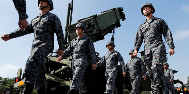 Des soldats des forces japonaises d'autodefense passent devant une unite de missiles patriot advanced capability-3 (pac-3)[reuters.com]