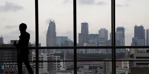 La silhouette d'un homme devant les gratte-ciel de tokyo[reuters.com]