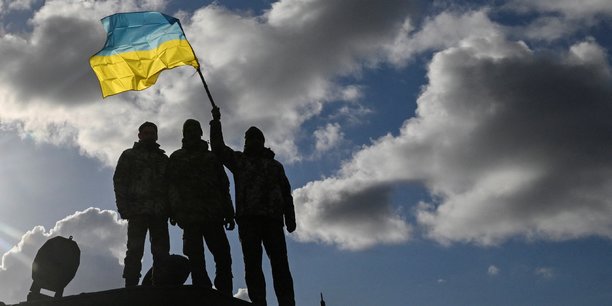 Des soldats agitent un drapeau ukrainien[reuters.com]
