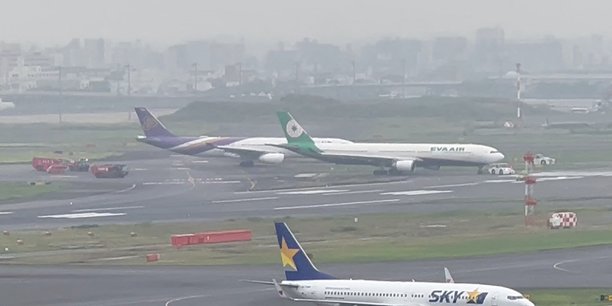 Photo des avions de thai airways et d'eva airways  a l'aeroport international de tokyo-haneda[reuters.com]