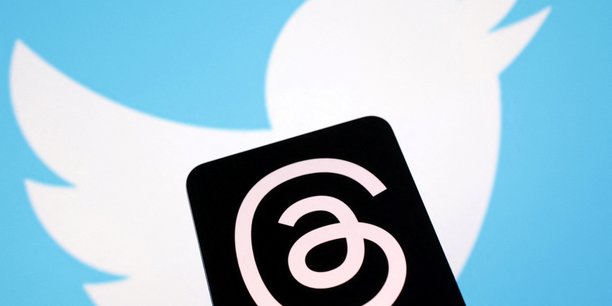 Le logo de Threads (en noir) sur celui de Twitter.