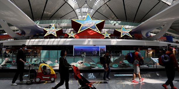 Photo d'archives des  voyageurs qui passent devant une installation en forme de cinq etoiles, a l'aeroport international de pekin daxing a pekin[reuters.com]