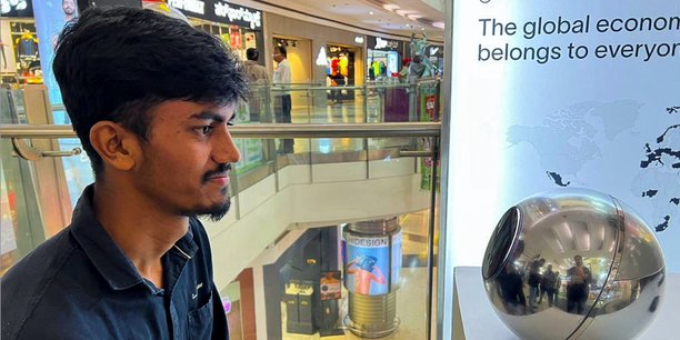 Un ingénieur de 22 ans à Bengalore s'inscrit à la crypto WorldCoin en se faisant scanner les yeux par le dispositif sphérique dans le centre commercial Mantri Square, en Inde, en juillet 2023.