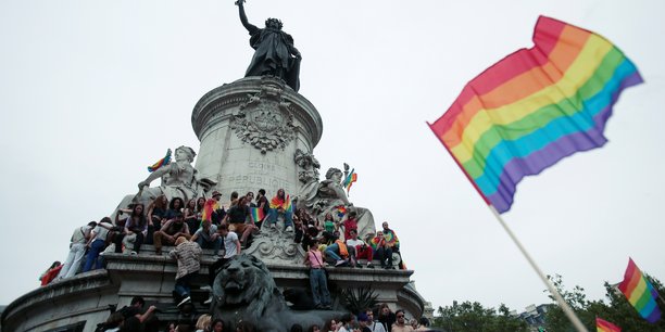 Des manifestants portant des drapeaux arc-en-ciel et des pancartes ors d'une marche des fiertes lgbtq a paris[reuters.com]