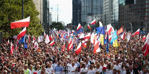 Donald tusk, chef de file de plateforme civique (po), le plus grand parti d'opposition en pologne, et rafal trzaskowski, le maire de varsovie, marchent devant le drapeau national polonais a varsovie[reuters.com]