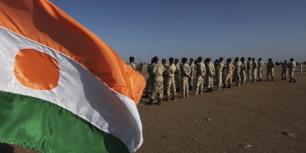 Soldats en formation pres d'un drapeau nigerien[reuters.com]