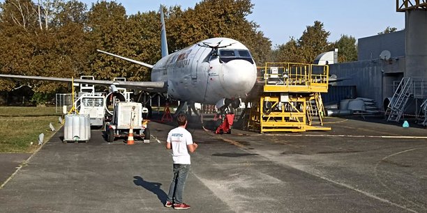 Opération de nettoyage d'un avion au moyen d'un drone sur le site aéroportuaire de Bordeaux-Mérignac.